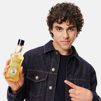 Reuzel Road Trip To Go 3-in-1 Tea Tree Shampoo, conditioner, and body wash bottle with label and cap.