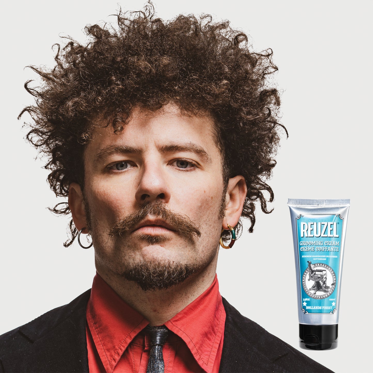 Reuzel grooming cream in a jar, showcasing the hair styling product with a smooth, creamy texture for styling and hold.