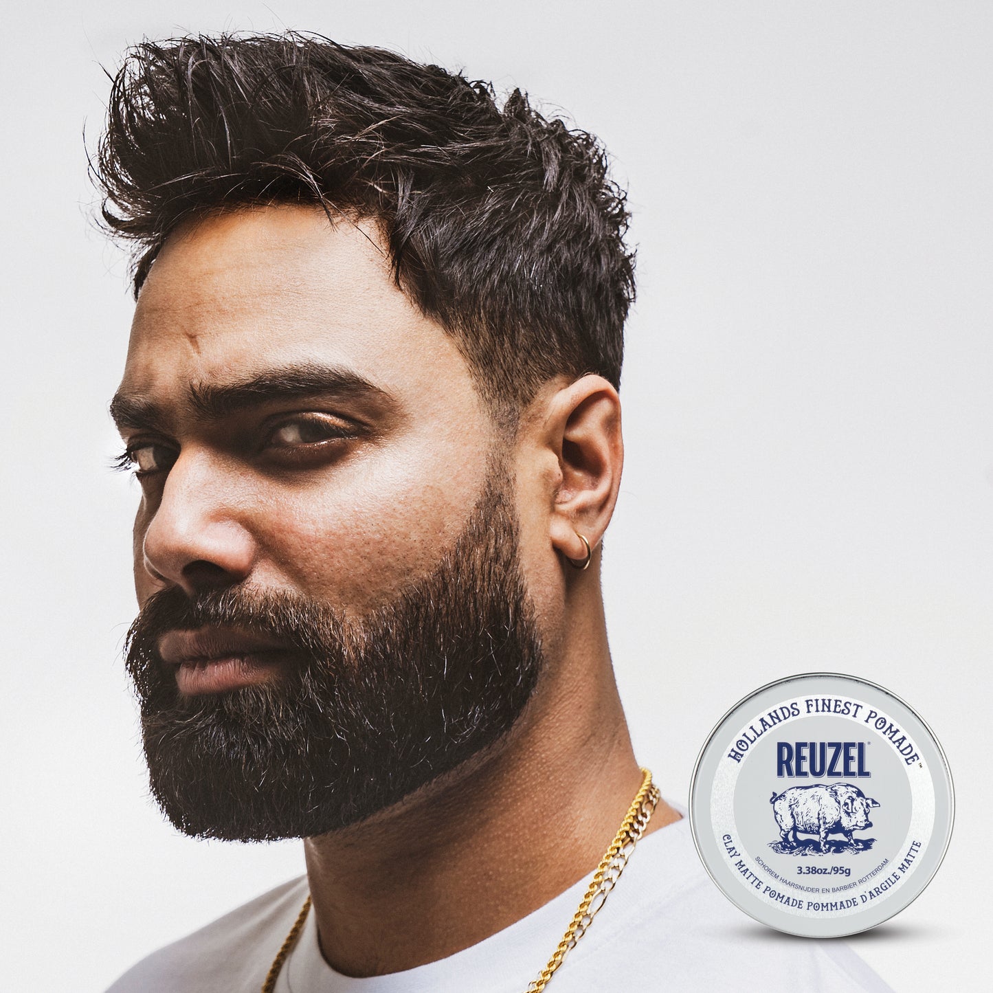 Reuzel Road Trip To Go Clay Pomade jar with black lid and label, showcasing the styling product for textured, matte hair styles.