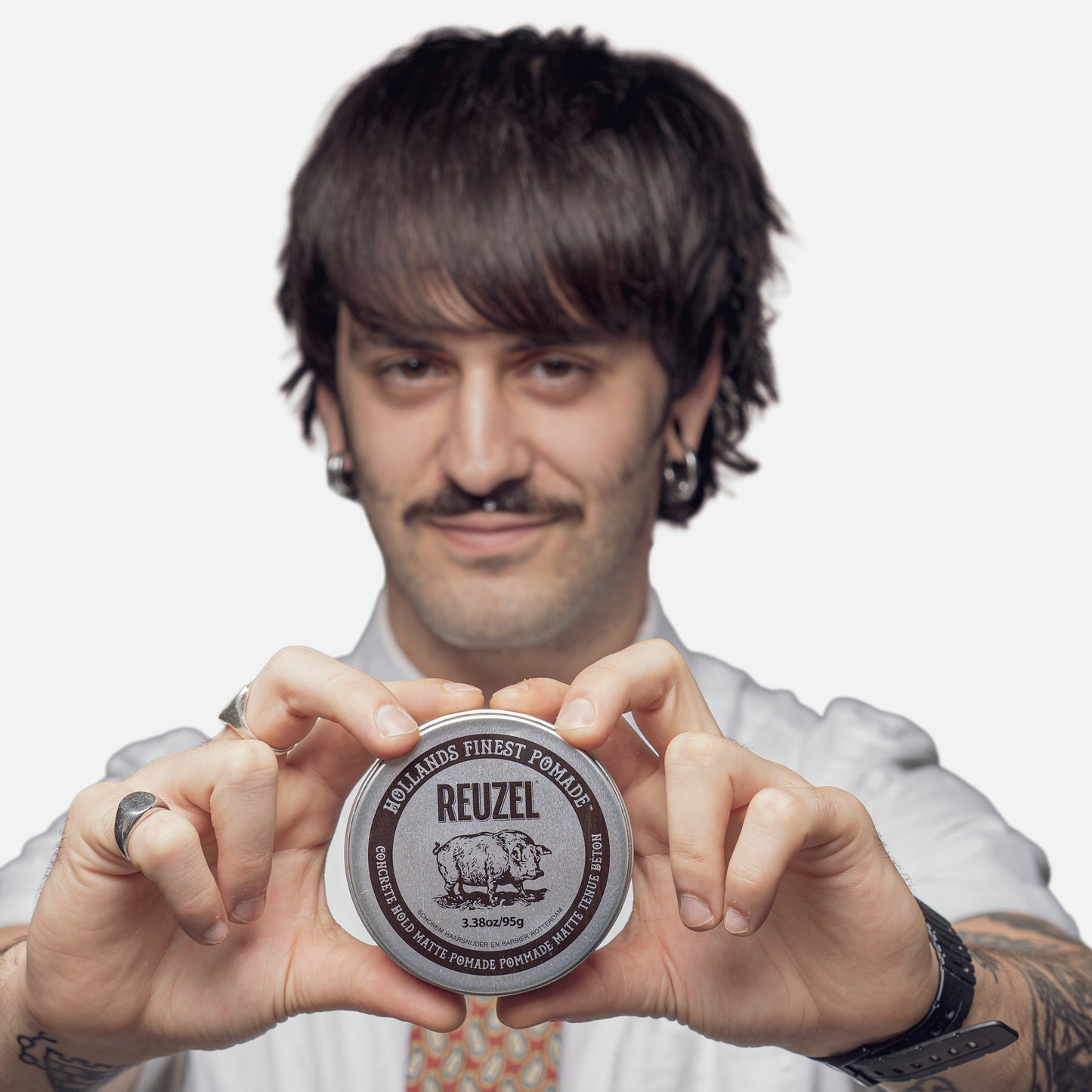 Reuzel Concrete Hold Matte Pomade jar with black label and product name, showing the pomade's matte finish and textured container.