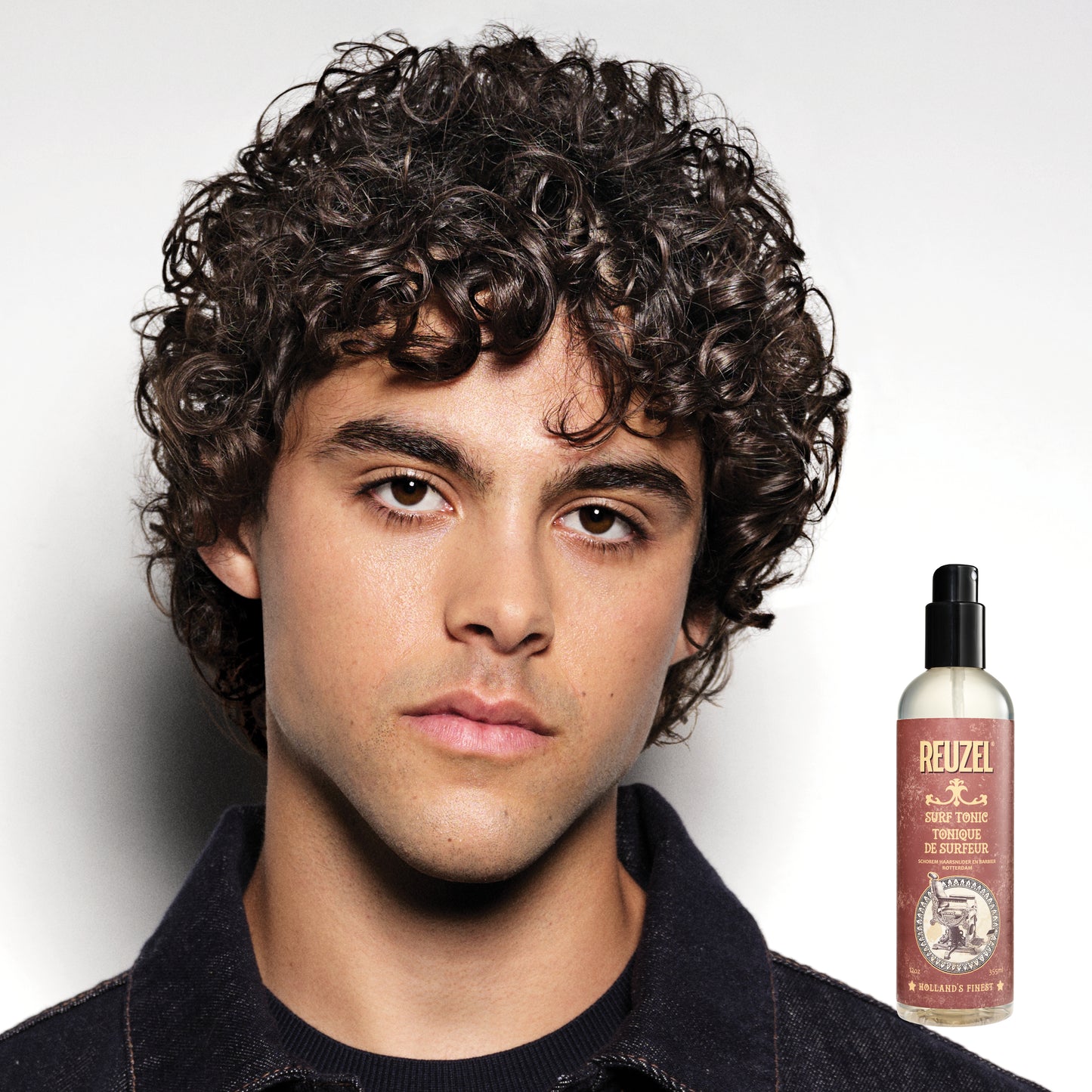 Reuzel Surf Tonic salt spray bottle for textured, beachy hair styling, shown in a close-up image.