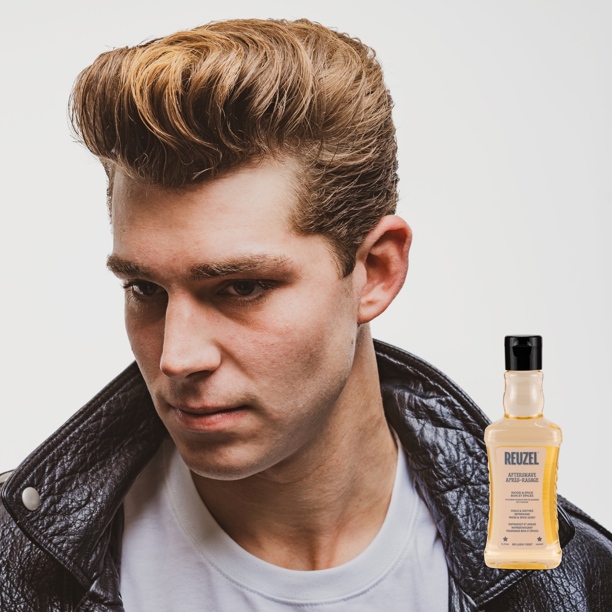Reuzel Wood & Spice beard aftershave bottle with a wooden cap, featuring warm spice scent and masculine branding.