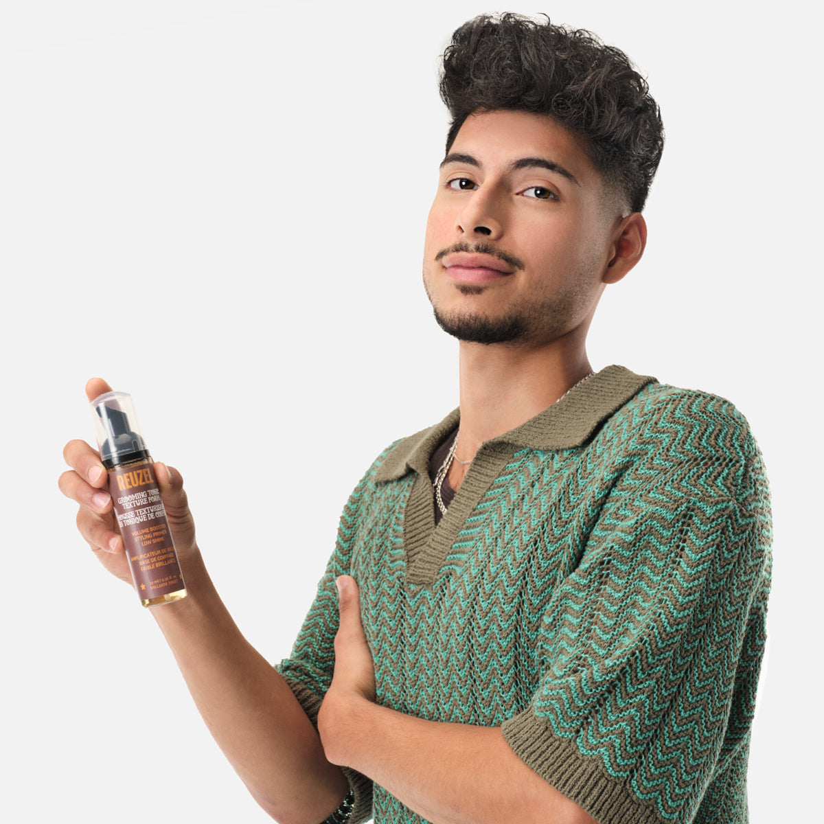 Reuzel Grooming Tonic Texture Foam for hair styling, showing the foamy product in a white bottle on a neutral background.